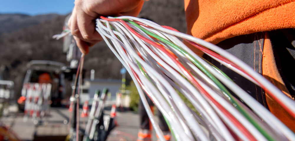 Ein Arbeiter montiert Glasfaserkabel der Swisscom fuer den Internetansschluss von Privathaushalten, am Dienstag, 10. Februar 2015 in Bellinzona. Die staedtischen Betriebe Bellinzona "Aziende Municipalizzate Bellinzona" (AMB) bauen in Partnerschaft mit Swisscom ein neues Glasfasernetz. Im Laufe der naechsten fuenf Jahre sollen in Bellinzona und in einigen benachbarten Staedten rund 14'000 Wohnungen ans Netz angeschlossen werden. (KEYSTONE/Ti-Press/Carlo Reguzzi)